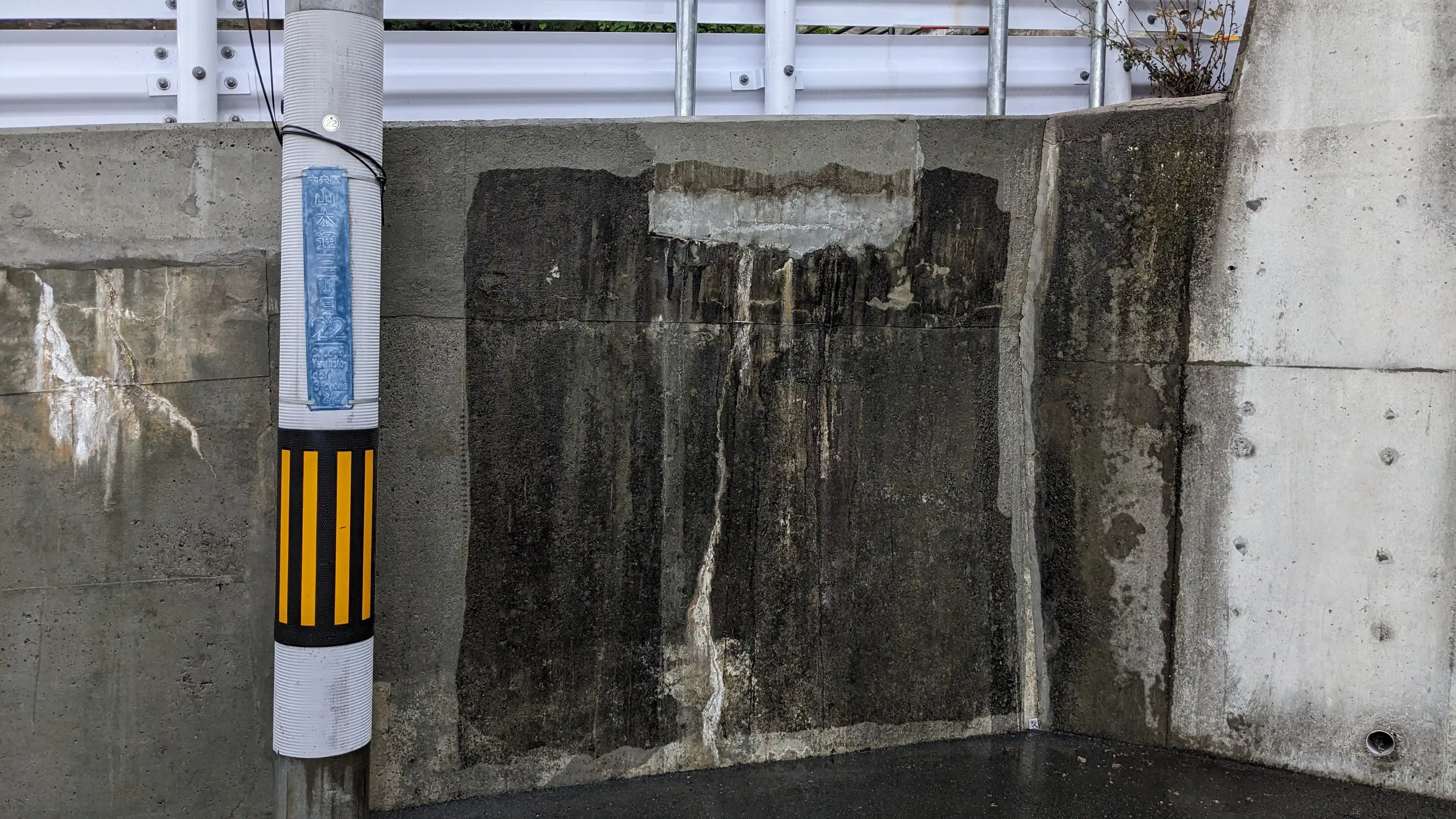 Concrete wall ramp beside power pole during pressure washing